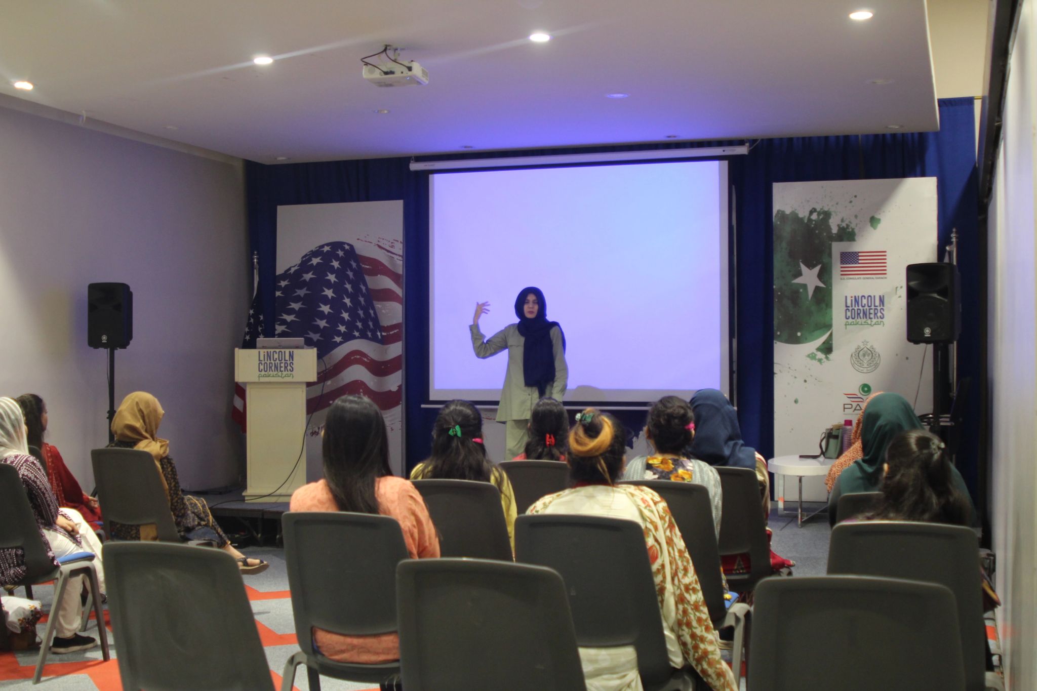 Maha speaking to an audience during a presentation event