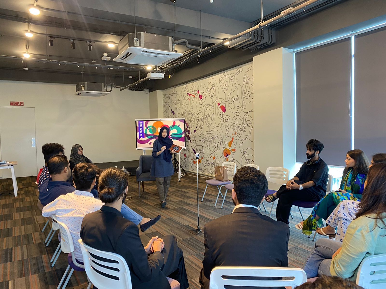 Maha facilitating a communication workshop with participants seated in a circle